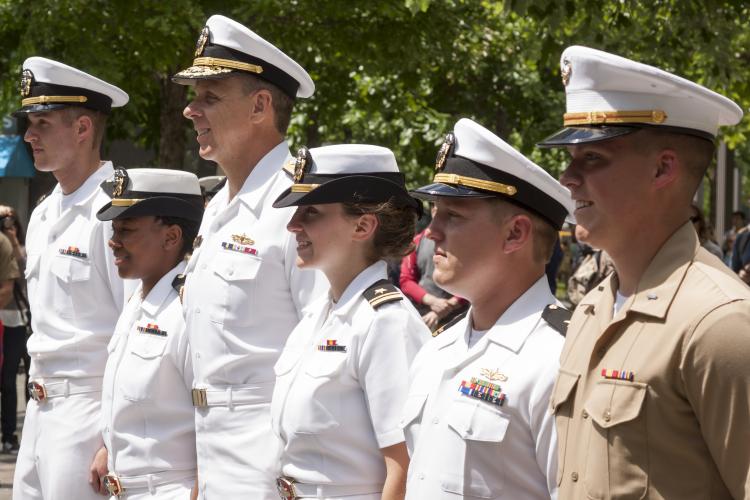 US Navy and Marine Corps personnel stand at attention.