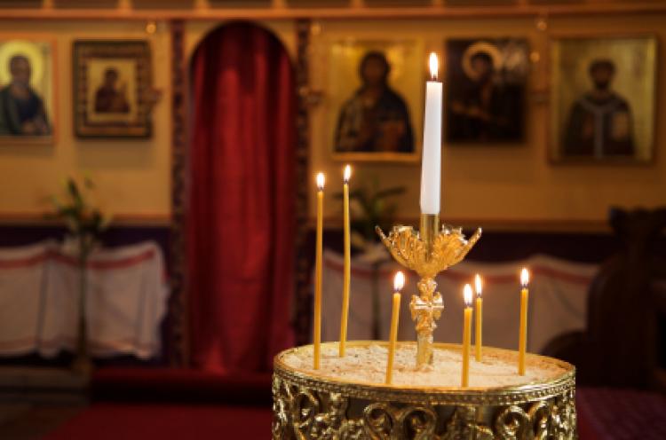Candle holder and orthodox icons in background