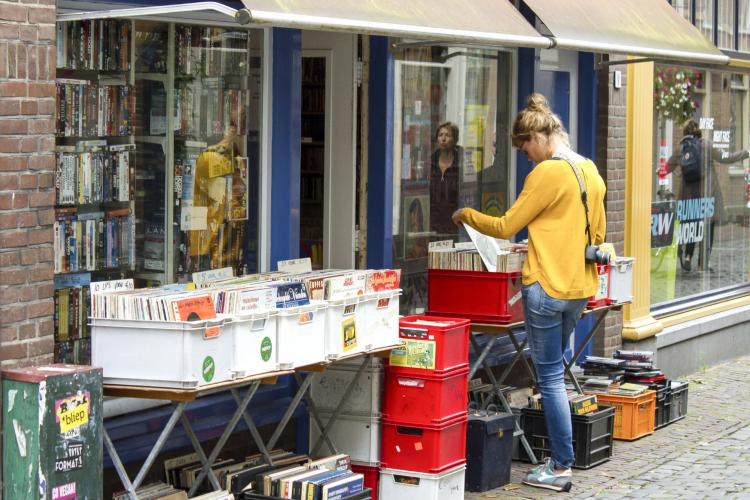 Woman browsing through records at a second-hand music and DVD store in Leiden, Netherlands.