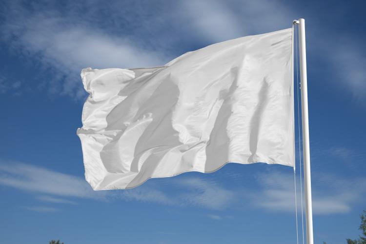 A white flag on the top of a flagpole.