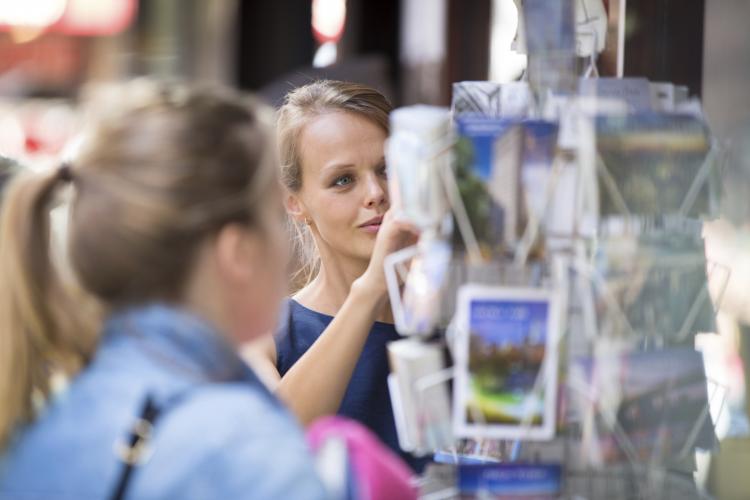 Young woman buying a postcard.