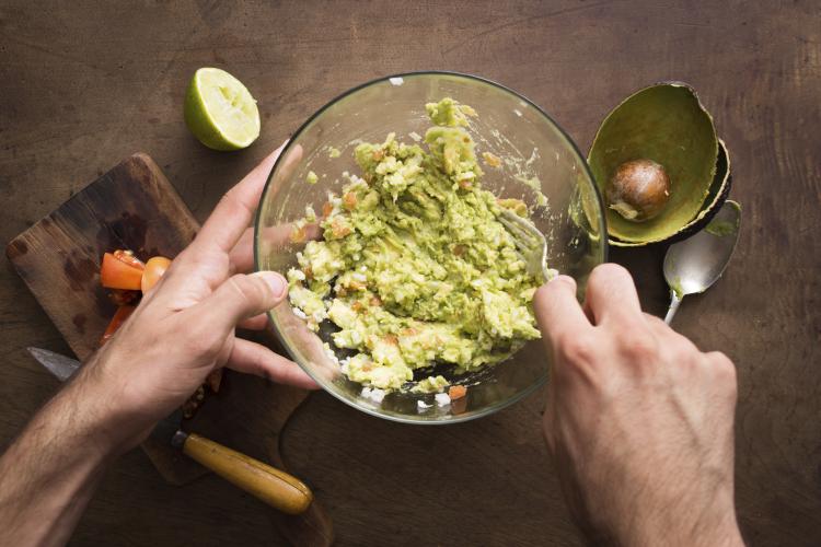 Mashing avocado to make guacamole.