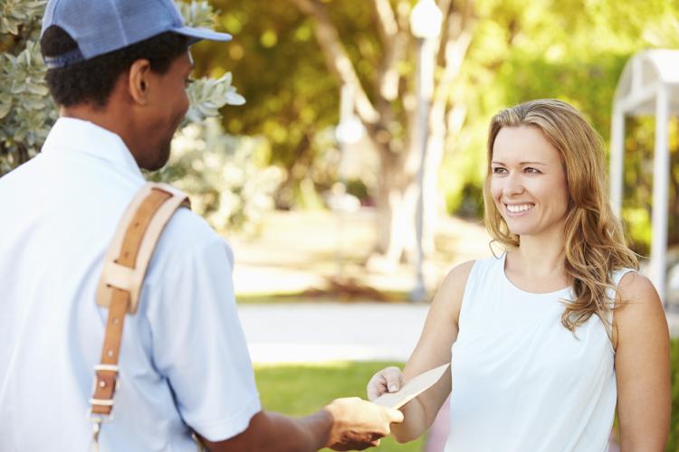 Mailman delivering letters to woman.