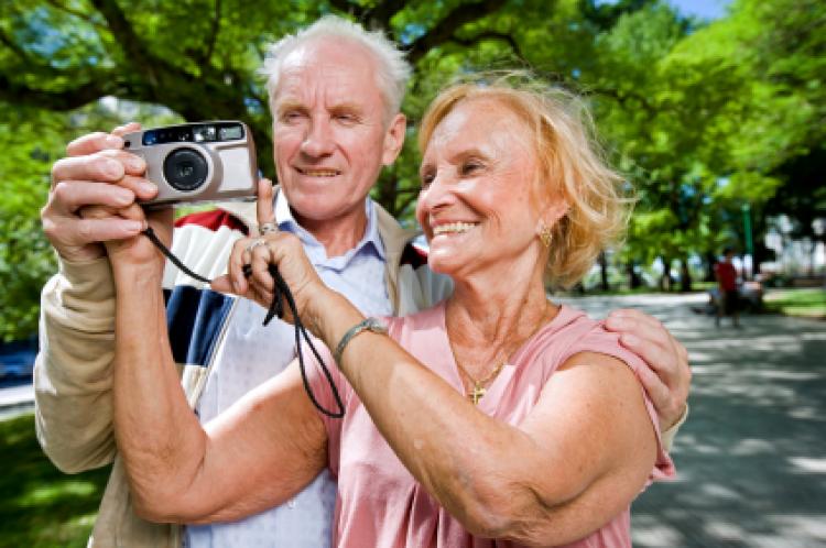 An senior couple with a camera, touring on vacation.