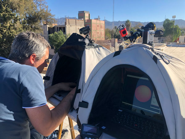Mann sjekker teleskop og teknisk utstyr