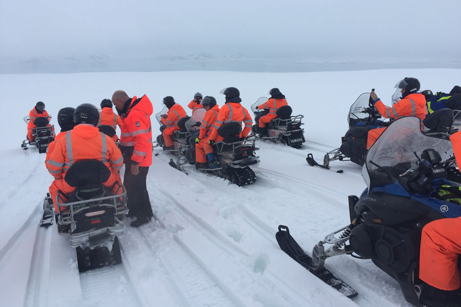 Ansatte kjører snømobil på Island